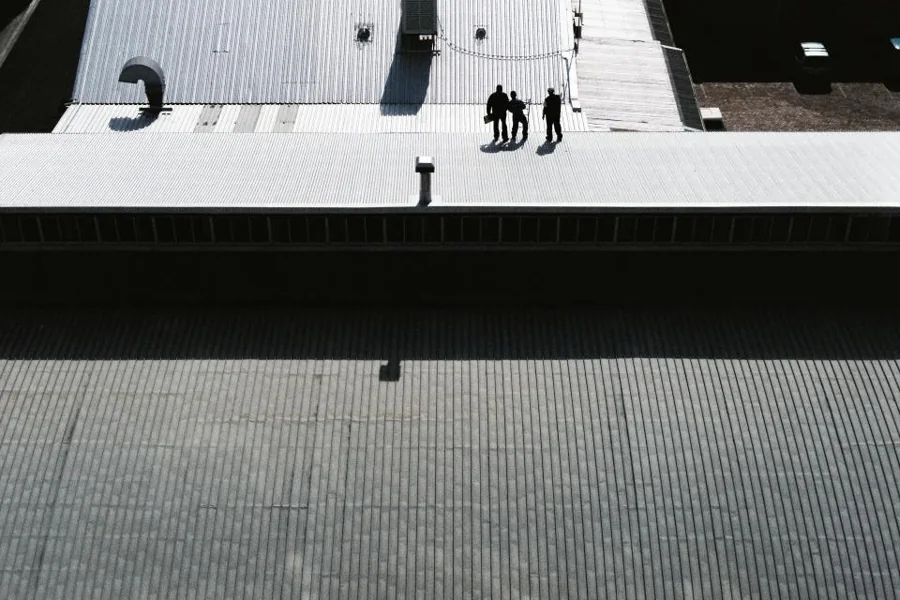 Workers on a large commercial metal roof